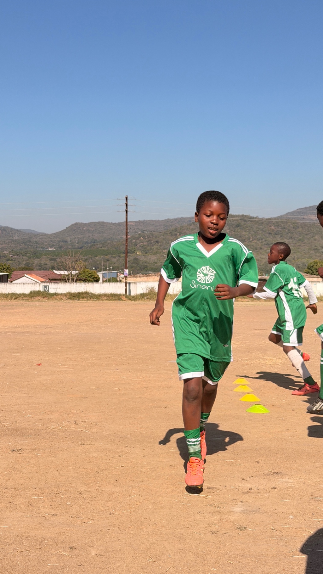 Young player running through cone drills